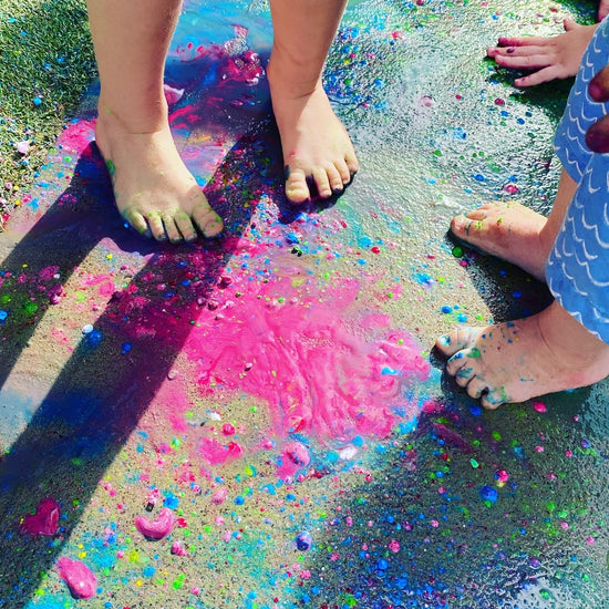 Toddlers paying in coloured chalk